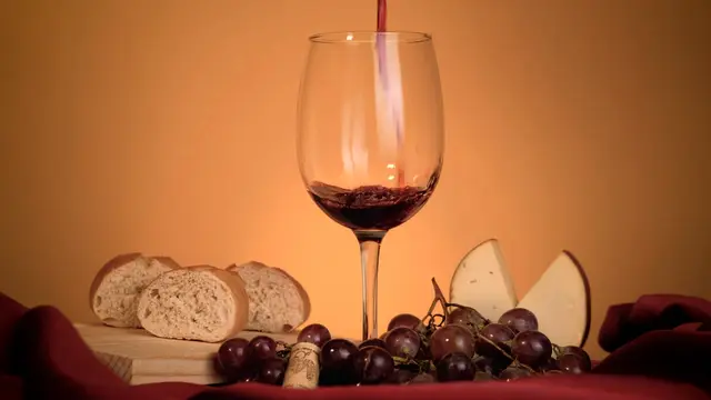 Copa de vino tinto con pan, uvas y queso